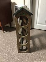 Front angled view showing circular cutouts for wine bottles, painted grapevine decoration on roof, natural wood and rustic condition.