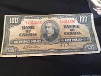 Full frontal view of the 1937 Bank of Canada $100 bill showing portrait in center and denomination markings.