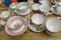 Overview of all six tea sets with various floral patterns and gold trim on the cups and saucers.