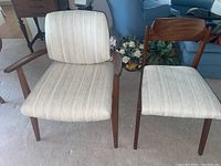 Two chairs side by side on carpet—one armchair and one side chair