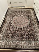 Full view of the rectangular rug laid out on the floor showing entire pattern and border.