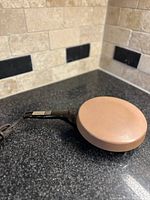 Side view of vintage Oster crepe maker showing ceramic cooking surface and handle with cord