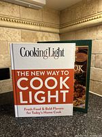 Two vintage cookbooks standing upright in a kitchen corner, showing the covers.