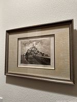 Angled view of the framed vintage landscape drawing depicting Mont Saint Michel island and abbey.