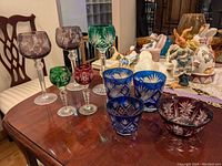 Overview of various cut to clear glasses and trinket bowls on wooden table.