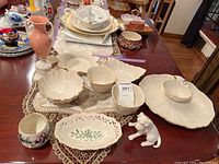 Overview of all Lenox pieces including serving bowls, dishes, and dog figurine displayed on table with lace runner.
