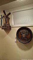 Wide view showing the Dinkel Acker CD-Pils beer barrel sign and the Heineken windmill sign mounted on a wall.