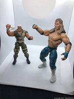 Two action figures pictured together in a light box; Shawn Michaels and soldier figure shown side-by-side