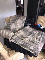 Queen comforter, pillows and sham pillow cases displayed on a table with printer and office supplies in background.