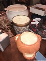 Three ceramic pots together on tabletop, showing colors and size comparison