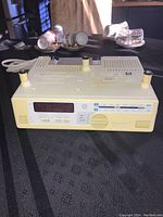 Front angled view showing the full top and front panel of the radio with control buttons and digital display