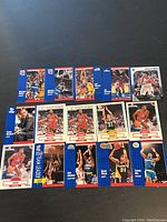 Photo showing 14 basketball cards including action shots of players and a coach's portrait.