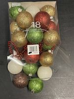 Boxed set of 18 shatterproof Christmas ball ornaments with red, green, white, and gold glitter finishes, made from durable plastic.