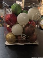 Packaged set of 18 Martha Stewart Everyday glittery shatterproof Christmas ball ornaments in assorted colors including red, green, white, gold, and bronze.