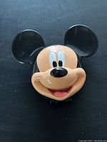 Front view of the Mickey Mouse shaped mobile phone showing face details.