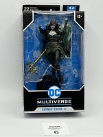 Front view of Batman Earth-II Dark Nights: Metal action figure in original packaging showing figure and trident accessory.