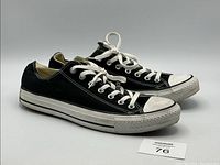 Side view of the pair of Converse black canvas low-top sneakers showing the complete shoe profile and condition.