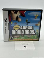 Front view of the closed New Super Mario Bros Nintendo DS game case with cover art and Nintendo DS label visible.