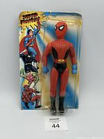 Front view of Super Powers Spider Man action figure in sealed blister pack original packaging with artwork of Superman, Batman, and Robin on the left side of the card.