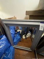 Photo of a large rectangular mirror with a silver frame, dimensions approximately 37x31 inches, showing the reflective surface and the metallic frame.