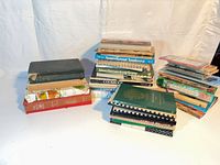 Three stacks of approximately 35 assorted cookbooks and booklets