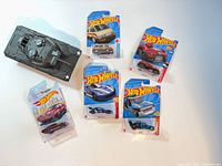 Group shot of five carded Hot Wheels cars and loose tank