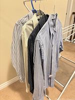 Five striped dress shirts hung on rack