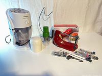 Group shot showing apple peeler box, ice crusher, two choppers, banana stand