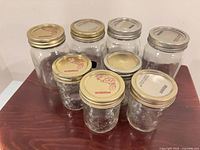 Group of eight mason jars showing both sizes and lids