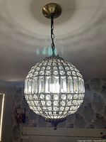 Full view of crystal globe chandelier lit