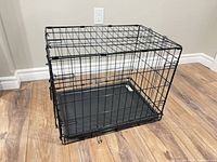 Overall view of assembled black wire dog crate with tray inserted