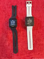 Black and white Garmin Forerunner 35 watches on red background