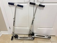 Both Razor scooters standing folded for size and overall view
