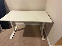 Full view of white height-adjustable desk