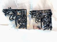 Four decorative black metal shelf brackets and hardware bag