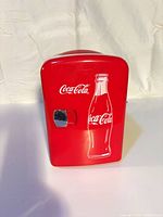Front view of red Coca-Cola mini fridge with bottle graphic
