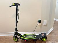 Full view of Razor Power Core E90 scooter plugged into wall charger