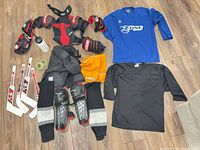 Full layout of youth hockey gear including protective equipment, jerseys, pants, gloves, mini sticks, accessories