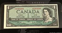 Full front view of 1954 Canadian 1 Dollar banknote showing Queen Elizabeth II portrait, denomination, serial number, and text.