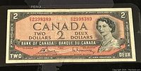 Front view of 1954 Canadian two dollar banknote with serial number and Queen Elizabeth II portrait.