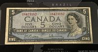 Front view of the 1954 Canadian five-dollar banknote showing Queen Elizabeth II portrait and serial numbers.