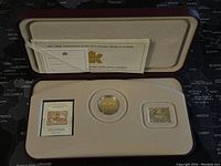 Photo of the entire set inside presentation case, includes commemorative coin, stamp replica, and certificate.
