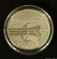 Reverse side of the coin showing the canoe design, denomination, year, and silver purity marks.