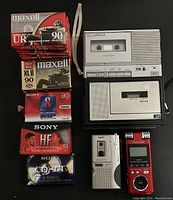 Full overhead image showing all cassette tapes stacked vertically and the cassette and digital recorders arranged side-by-side
