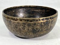 Side view showing the script-like etched design circling the bowl's exterior along with ornamental bands