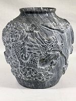 Front view of the marble vase showing the detailed carved dragon motif and the dark gray stone with white veining.