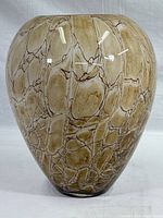 Full front view of the hand formed art glass vase showing marbled beige and brown pattern and glossy finish.