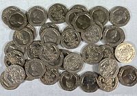 Photo showing unsorted UK 20 pence coins with Queen Elizabeth II obverse and Tudor rose reverse design spread on a cloth surface.