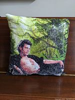 Front side showing printed image of Jeff Goldblum reclining with shirt open and natural green background.