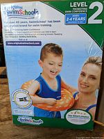 Box packaging showing SwimSchool Level 2 toddler floatation device for ages 2-4 years, maximum 33 lbs.